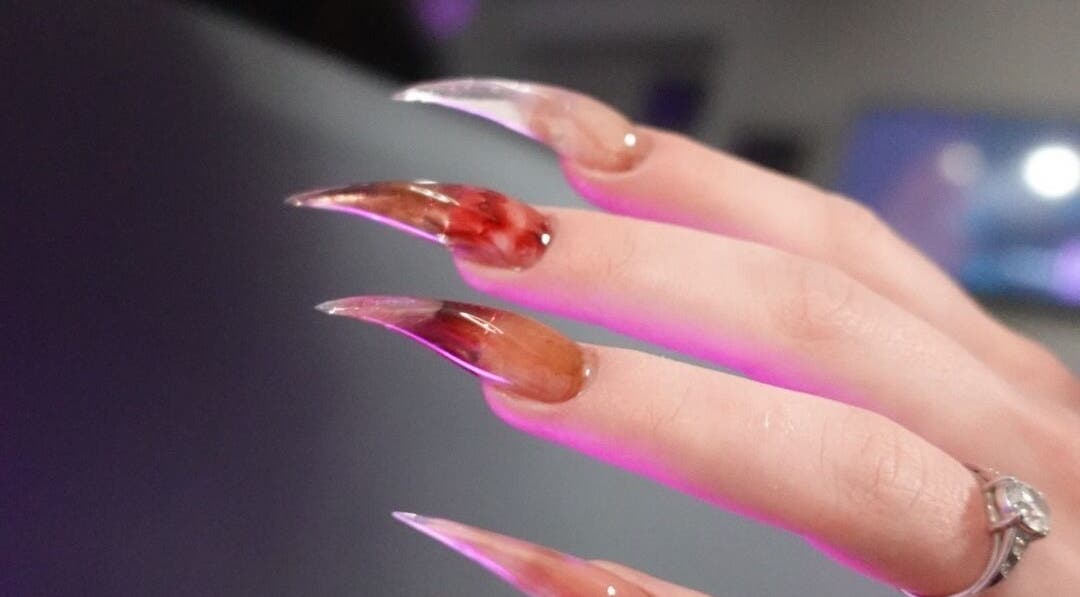 Stiletto-Nageldesign bei VG Beauty Center in Aschheim, Bayern, DE, mit rotem und braunem Farbverlauf.