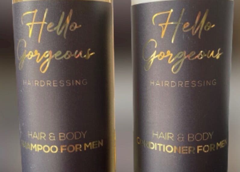 Men's hair products from Hello Gorgeous Hairdressing, London, England, GB. Sleek black bottles with gold text.