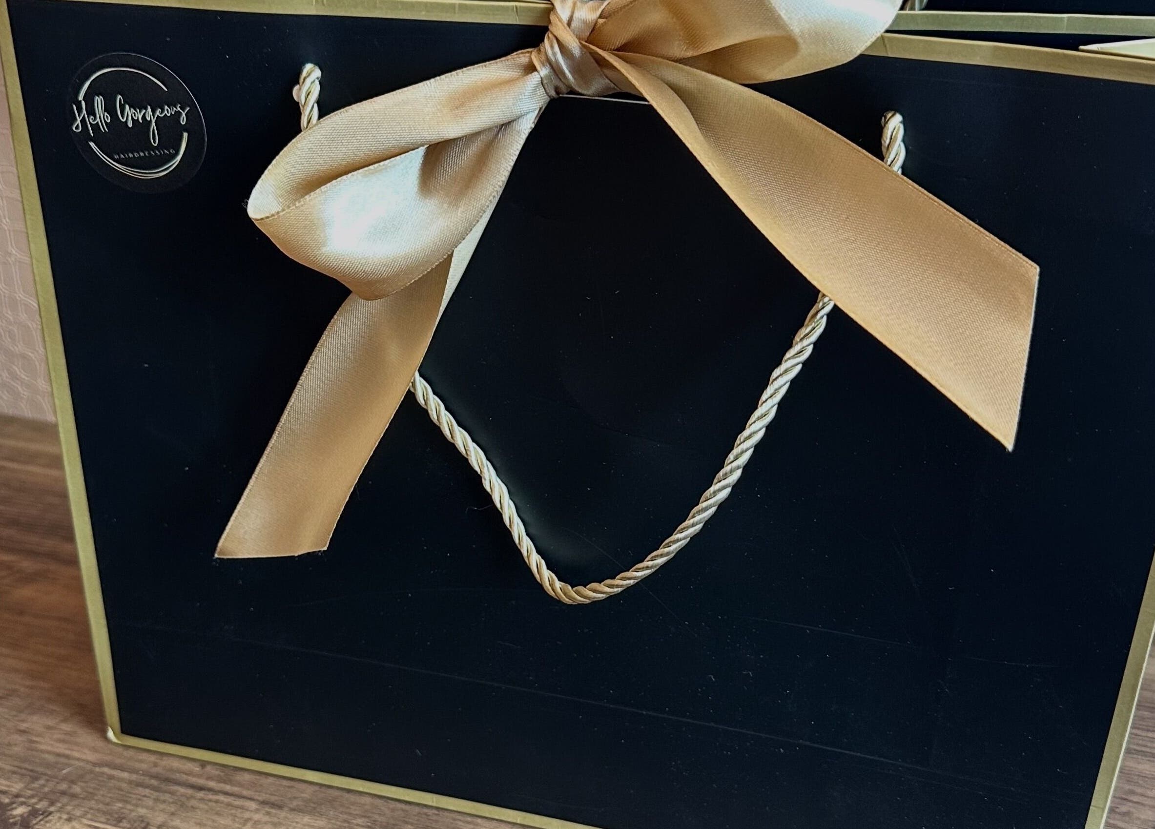 Elegant black and gold gift bag at Hello Gorgeous Hairdressing, London, England, GB.