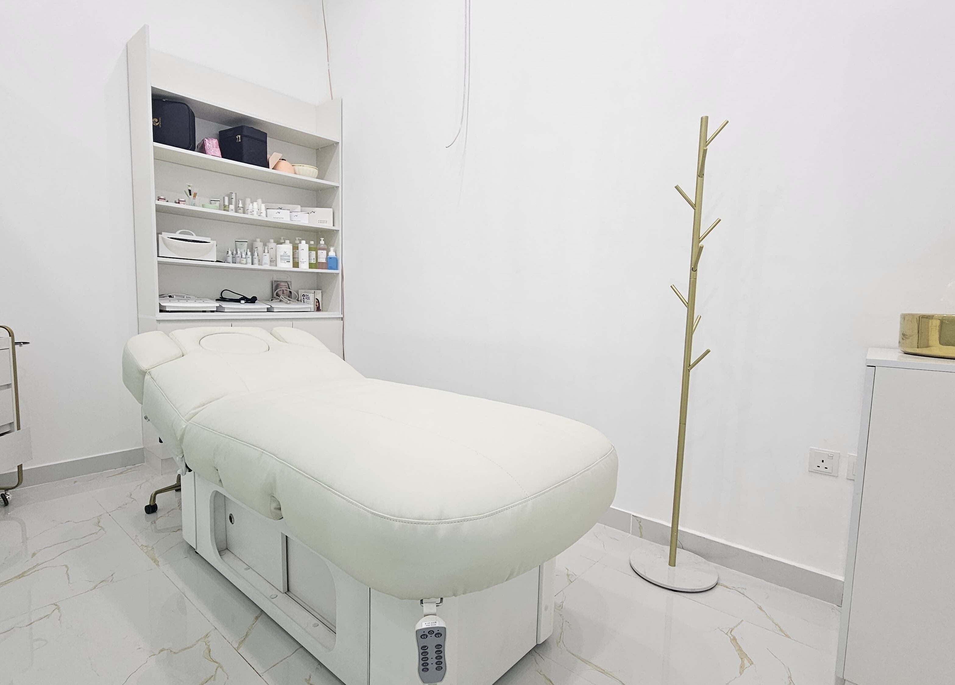 Calm treatment room at Azalea Beauty Center in Sharjah, AE featuring a white therapy bed and elegant decor.