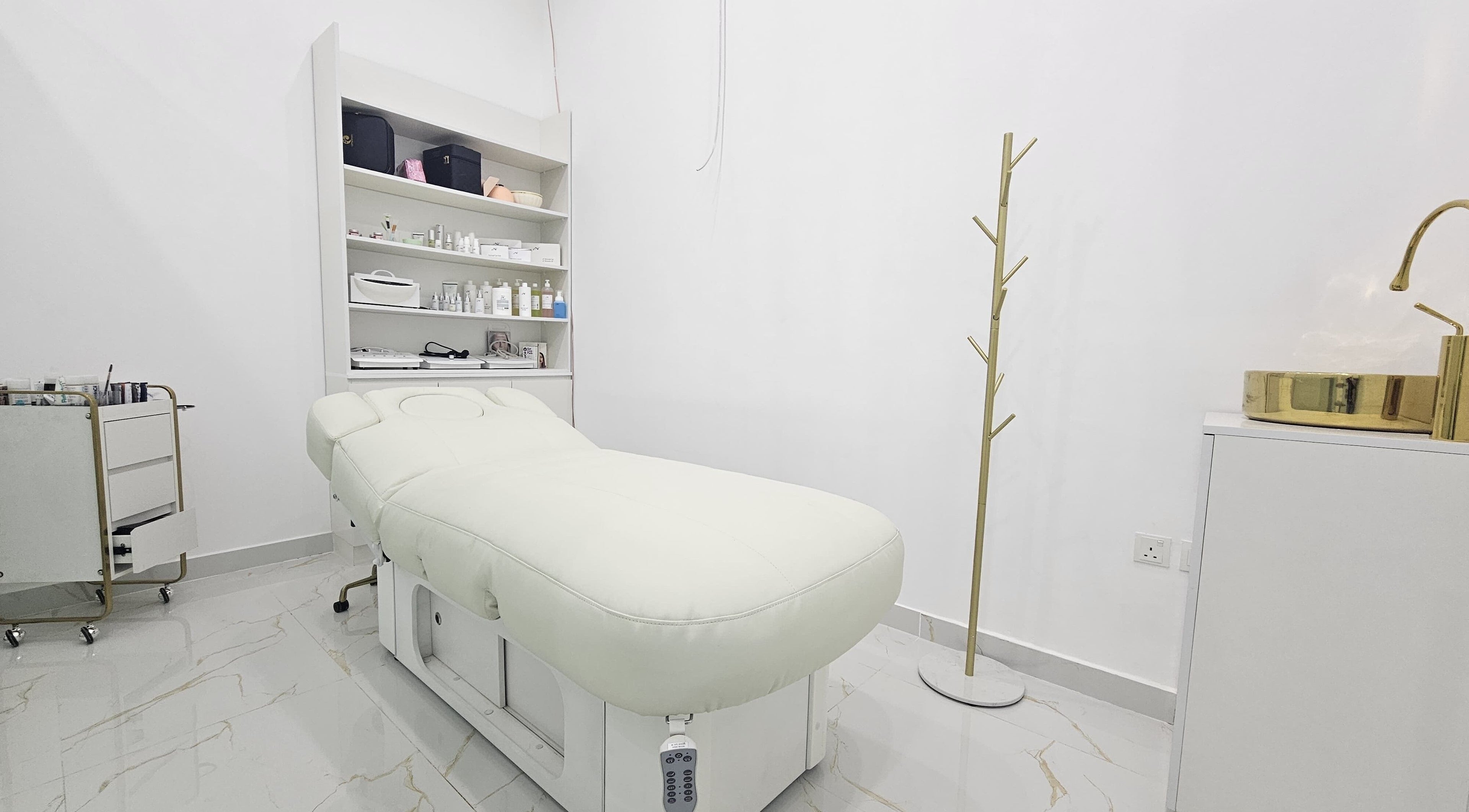 Calm treatment room at Azalea Beauty Center in Sharjah, AE featuring a white therapy bed and elegant decor.