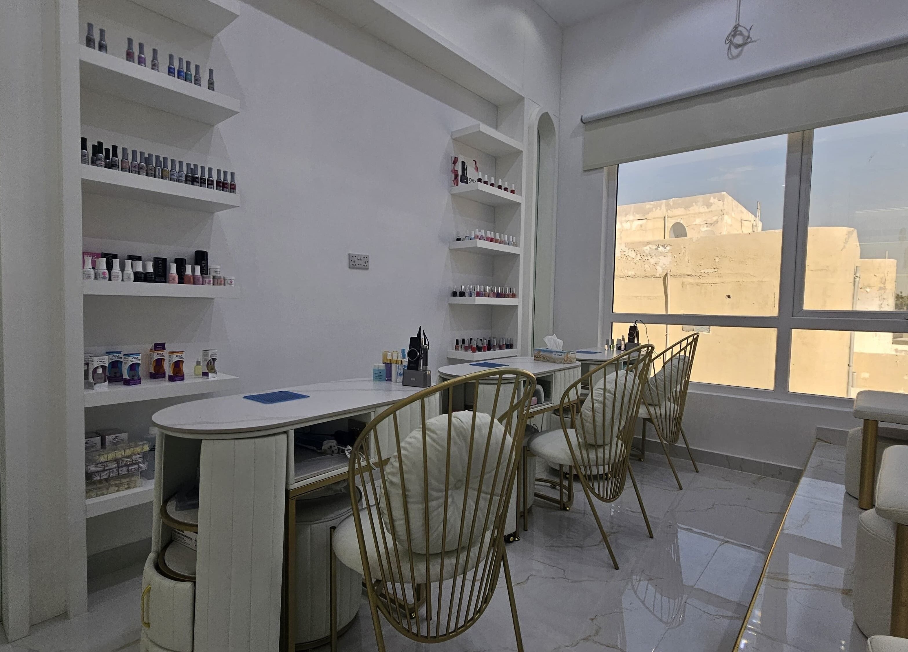 Nail lounge at Azalea Beauty Center, Sharjah. Stylish chairs and polishes on display.