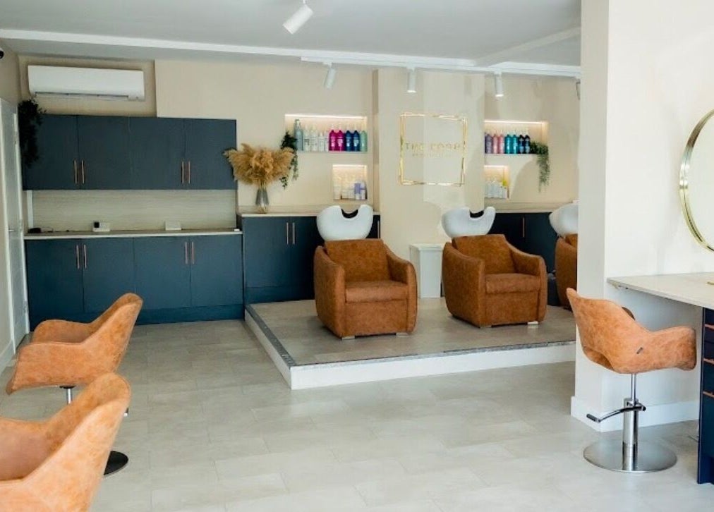 Modern salon interior at Stephanie Smith Hair, Aylesbury, England, GB with stylish brown chairs and sleek counters.