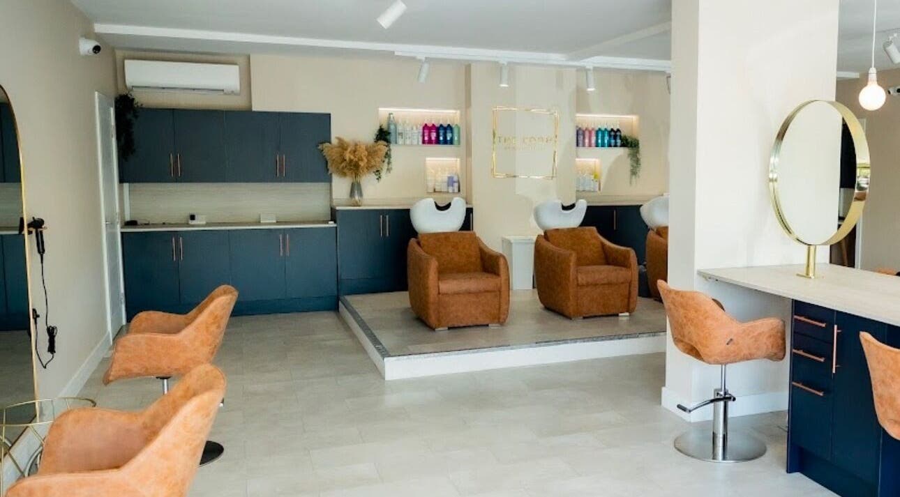 Modern salon interior at Stephanie Smith Hair, Aylesbury, England, GB with stylish brown chairs and sleek counters.
