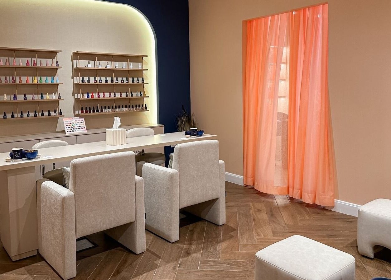 Modern nail bar at Re Beauty Space, Riyadh, Riyadh Province, SA, featuring cozy chairs and vibrant polish display.