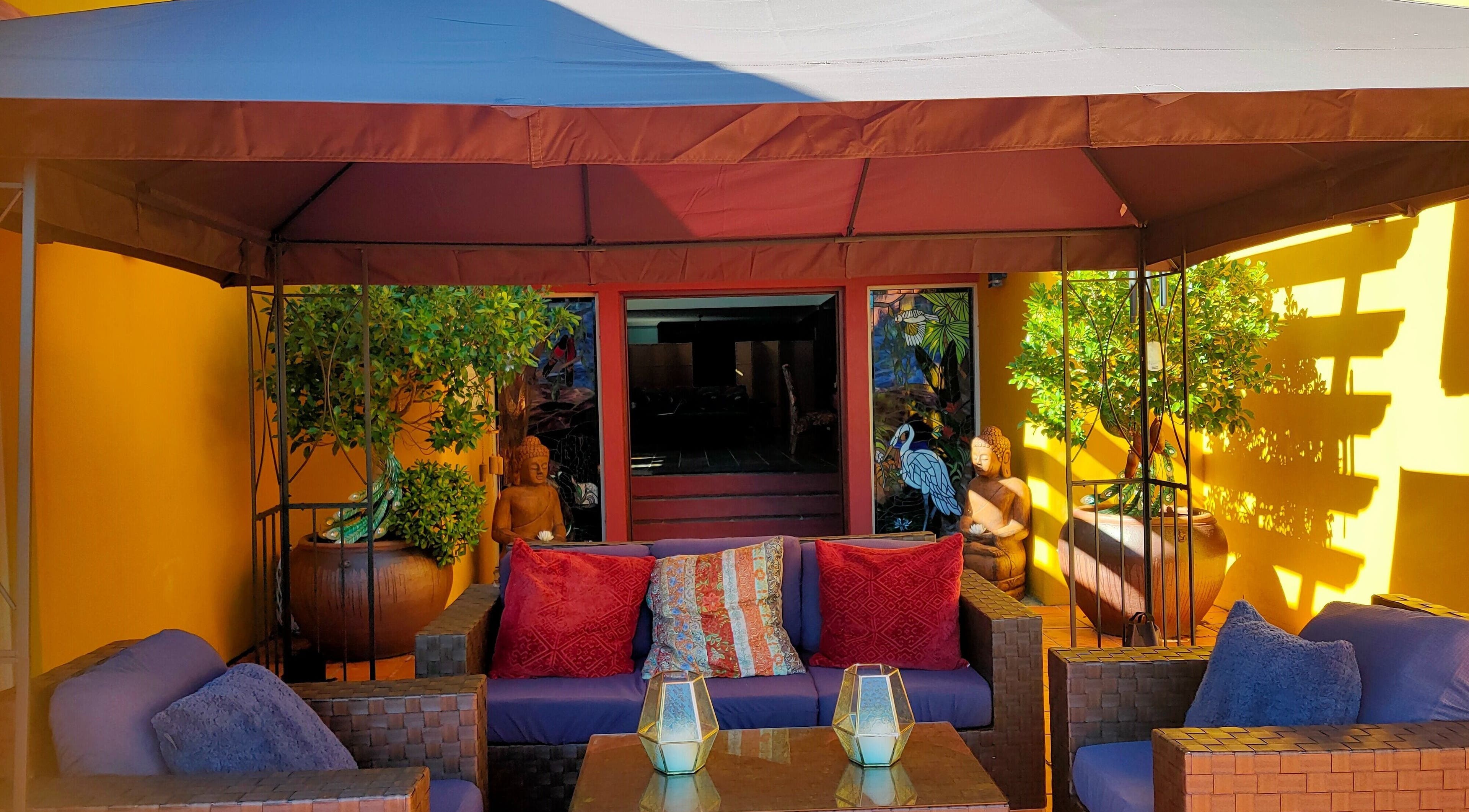 Outdoor lounge area at Blissage Day Spa Sanctuary, Tamborine Mountain, Queensland, AU with vibrant decor.