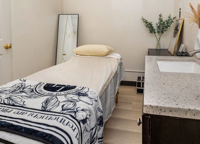 Relaxing treatment room at UM Beauty Studio, San Jose, California, US, featuring a cozy massage bed and soothing decor.