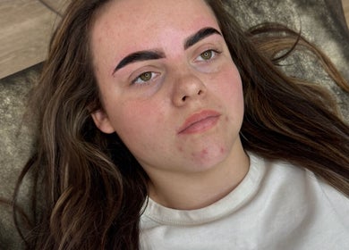 Woman with freshly shaped eyebrows at Browsbygraciee, Watford, England, GB, lying on a treatment chair.