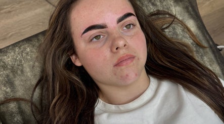 Woman with freshly shaped eyebrows at Browsbygraciee, Watford, England, GB, lying on a treatment chair.