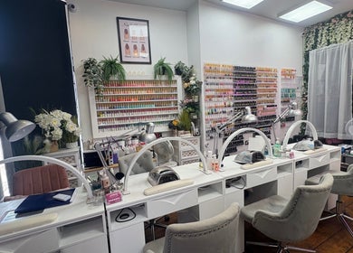 Stylish nail stations at Waritsara Studio Nails in Oundle, Oundle, England, GB with a wall of nail polish.