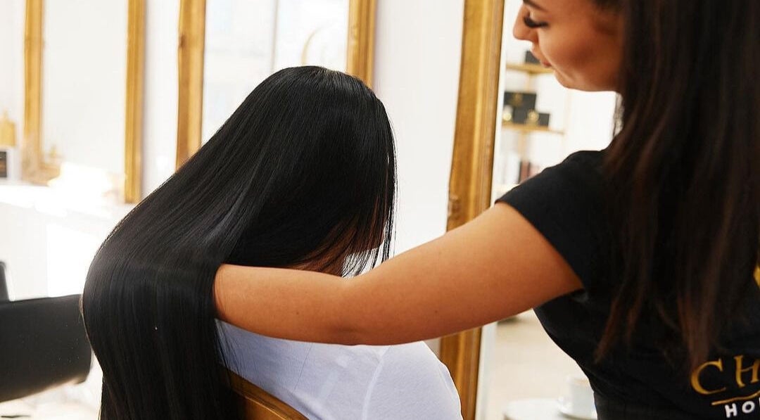 Stylist perfecting long hair at Chiara House of Hair, Warrawong, NSW, AU, in a luxurious setting.