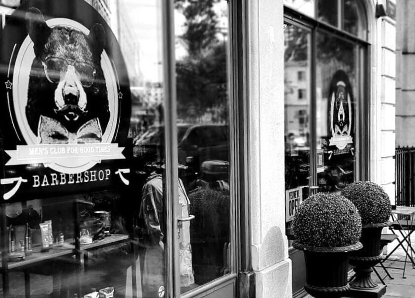 Entrance to Men's Club for Good Times in Genève showcases elegant barbershop style.