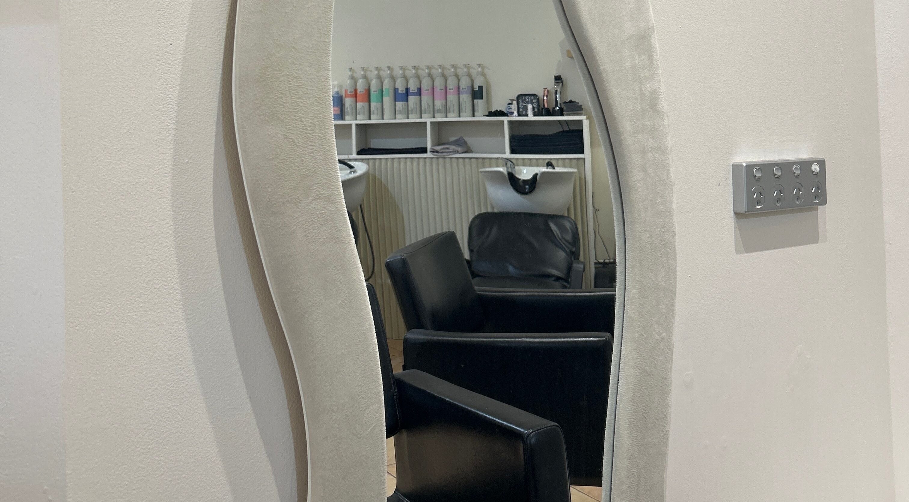 Elegant salon mirror reflecting chairs at Fuzion Hair & Beauty, North Yunderup, Western Australia, AU.