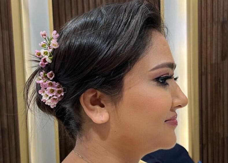 Elegant updo with flowers at Zaki Gents Salon - Anantara in Dubai, Dubai, AE for a refined look.