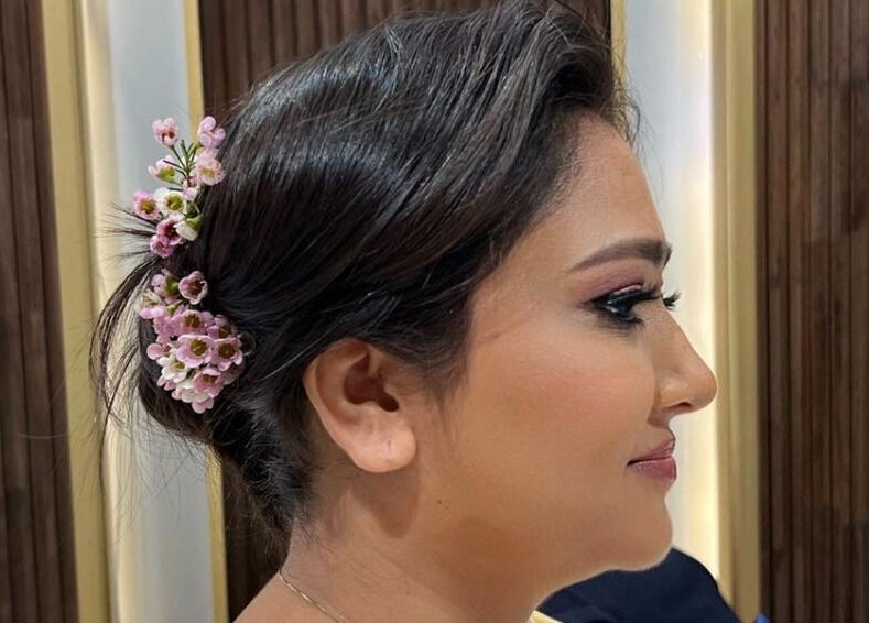 Elegant updo with flowers at Zaki Gents Salon - Anantara in Dubai, Dubai, AE for a refined look.