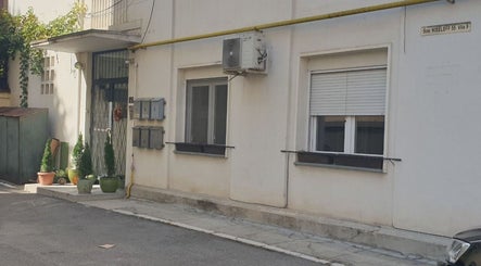 Entrance of Healthy Skin Lab - Liudmyla Dmytrenko, București, with potted plants and building details.