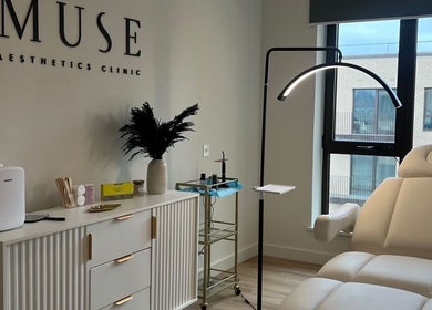 Luxurious treatment room at Muse Aesthetics, Greenford, England, GB with a plush chair and modern decor.