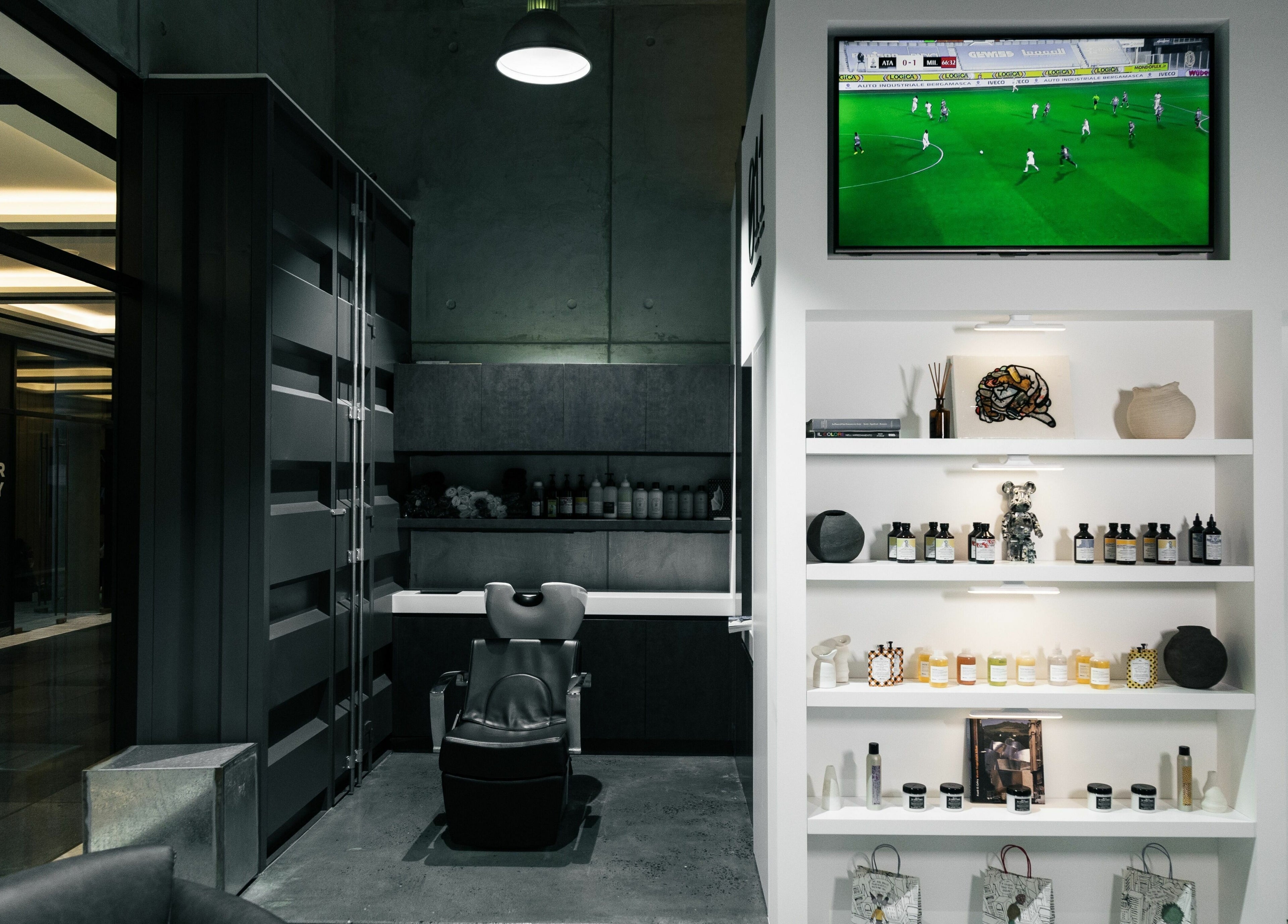 Sleek interior of 011 Italian Grooming DIFC in Dubai, Dubai, AE, showcasing a stylish barber chair and product display.