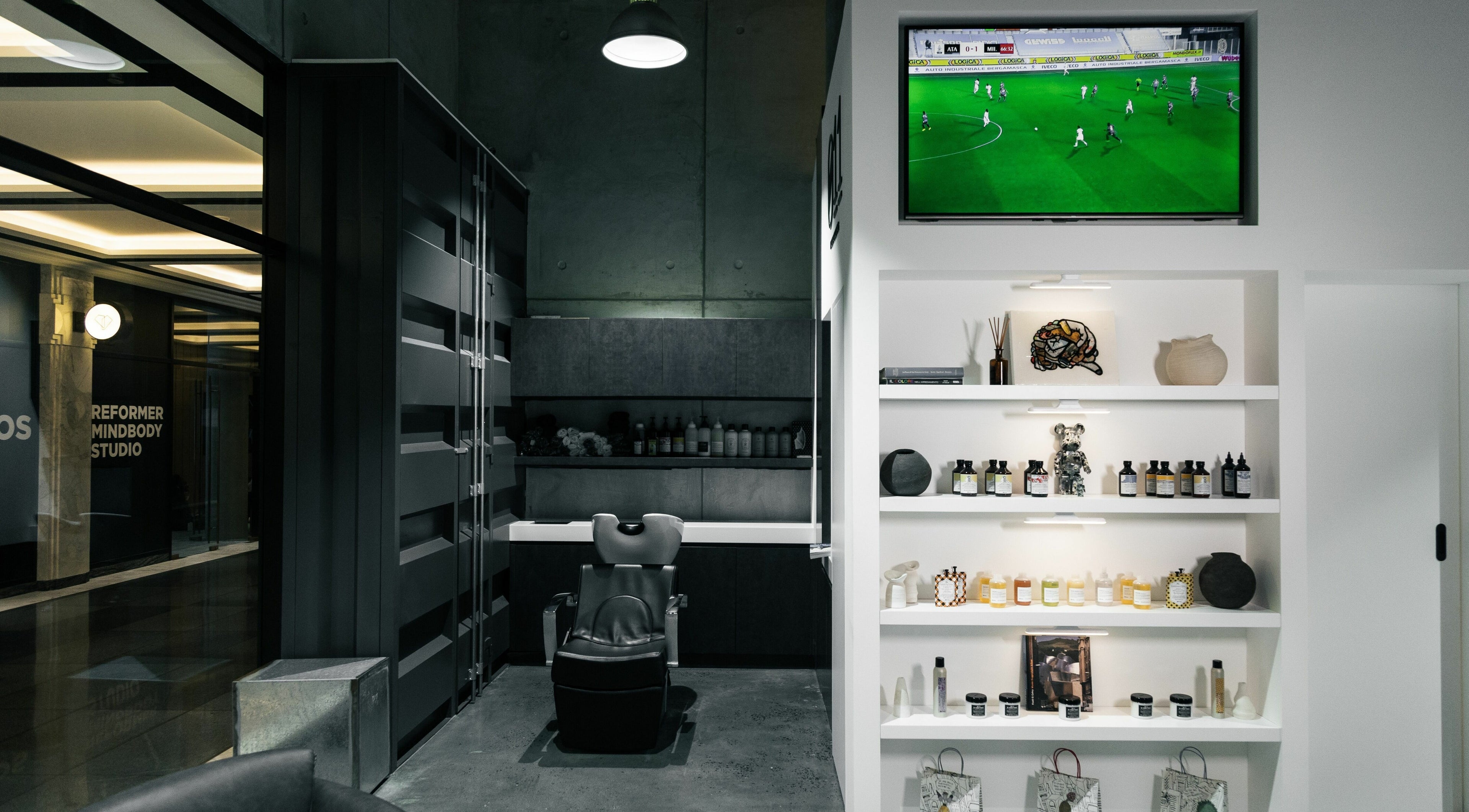 Sleek interior of 011 Italian Grooming DIFC in Dubai, Dubai, AE, showcasing a stylish barber chair and product display.