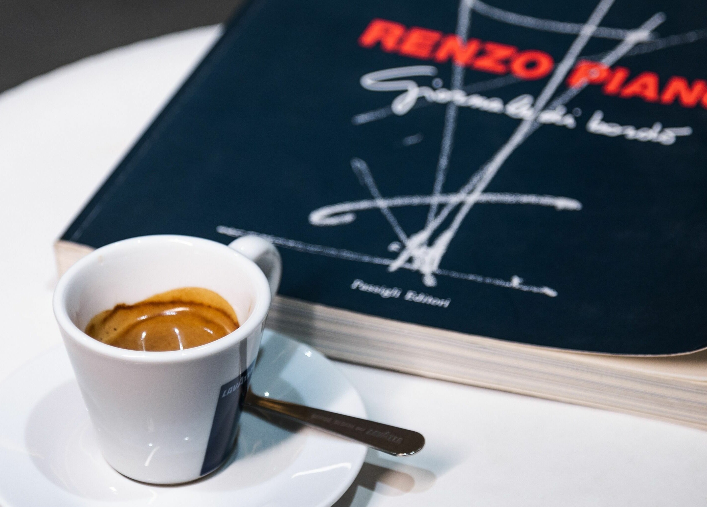 Espresso cup and book at 011 Italian Grooming DIFC, Dubai, Dubai, AE, showcasing relaxation and style.