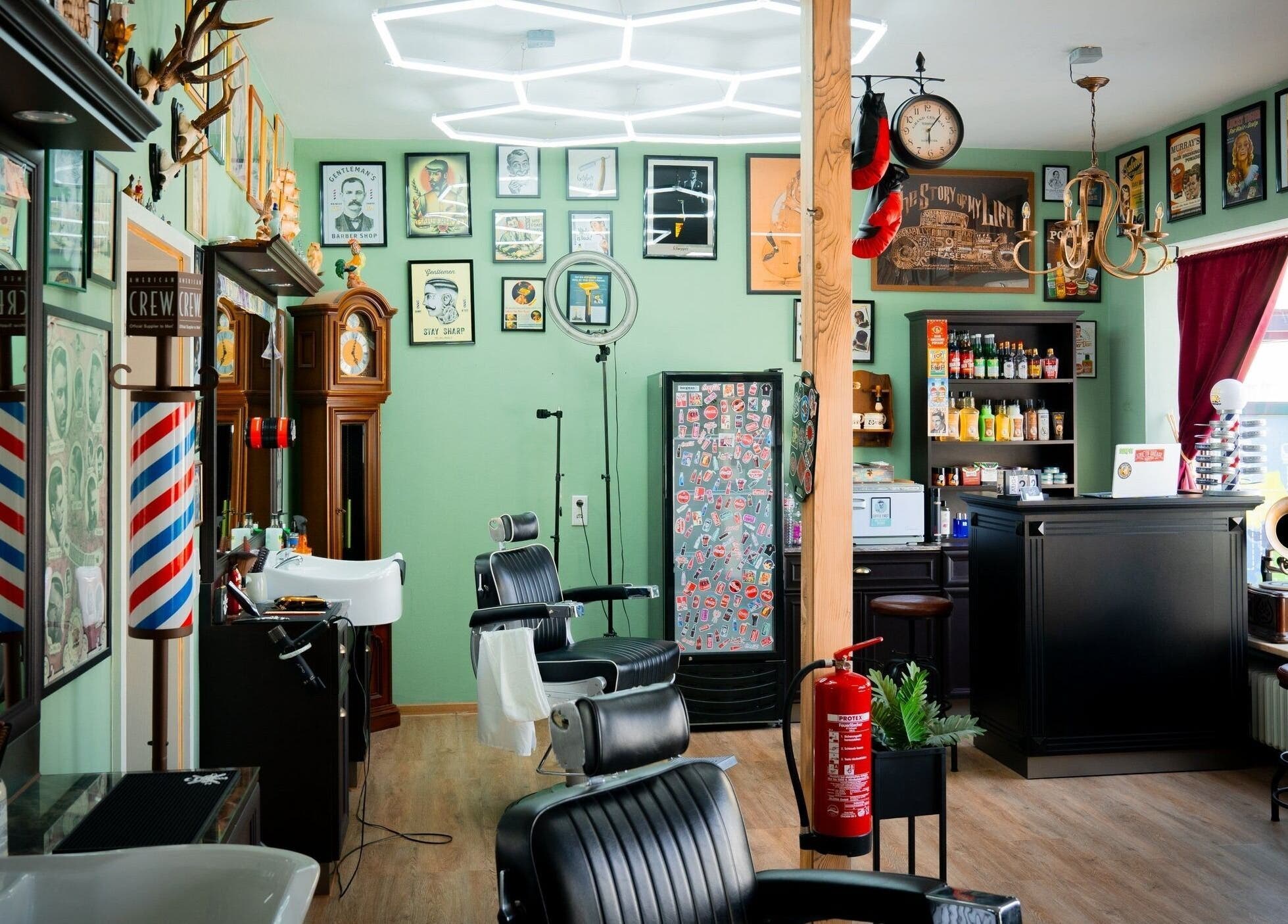 Innenansicht von Mens World Barbershop in Ingolstadt, Bayern, DE mit stilvollem Retro-Dekor und Barbershop-Stühlen.