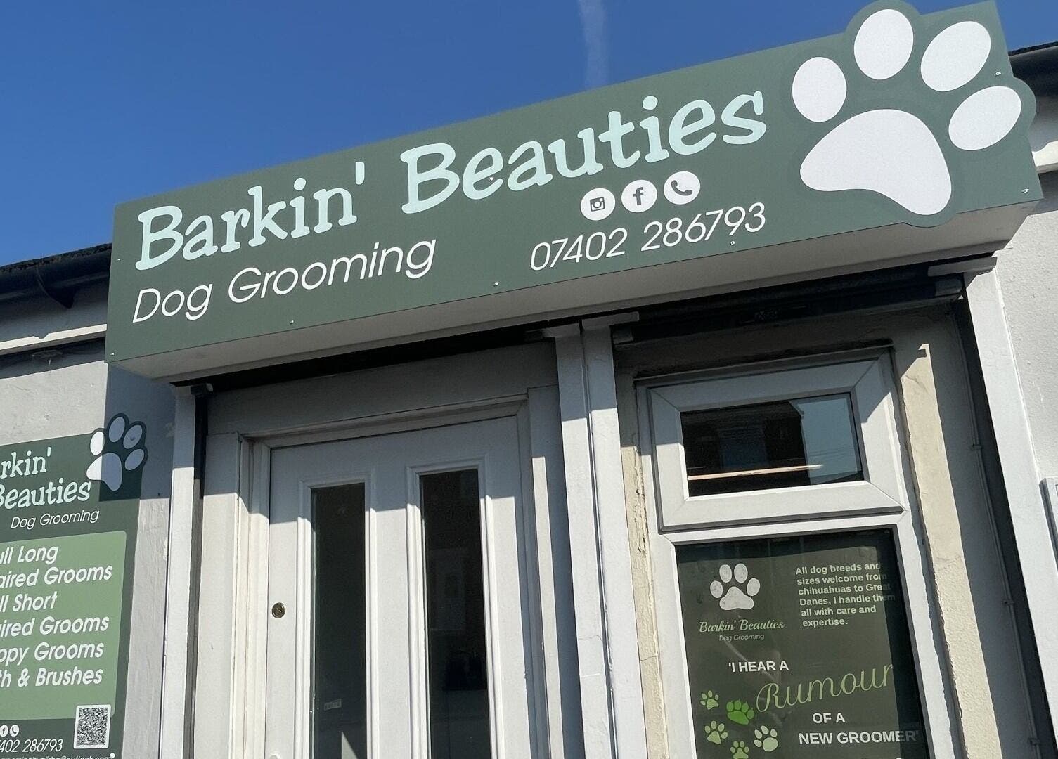 Front entrance of Barkin Beauties Dog Grooming in St Helens, England, showcasing signage and services.