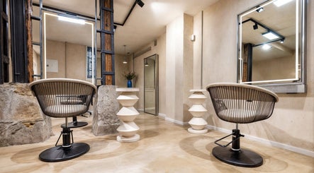 Interior moderno de ATICA Salón en Madrid, Comunidad De Madrid, ES con sillas elegantes y espejo iluminado.