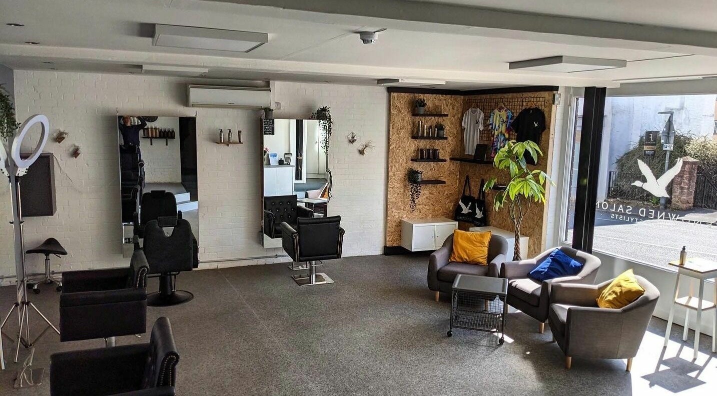 Spacious, modern interior of Renowned Hair, Exeter, England, GB with stylish seating and elegant decor.