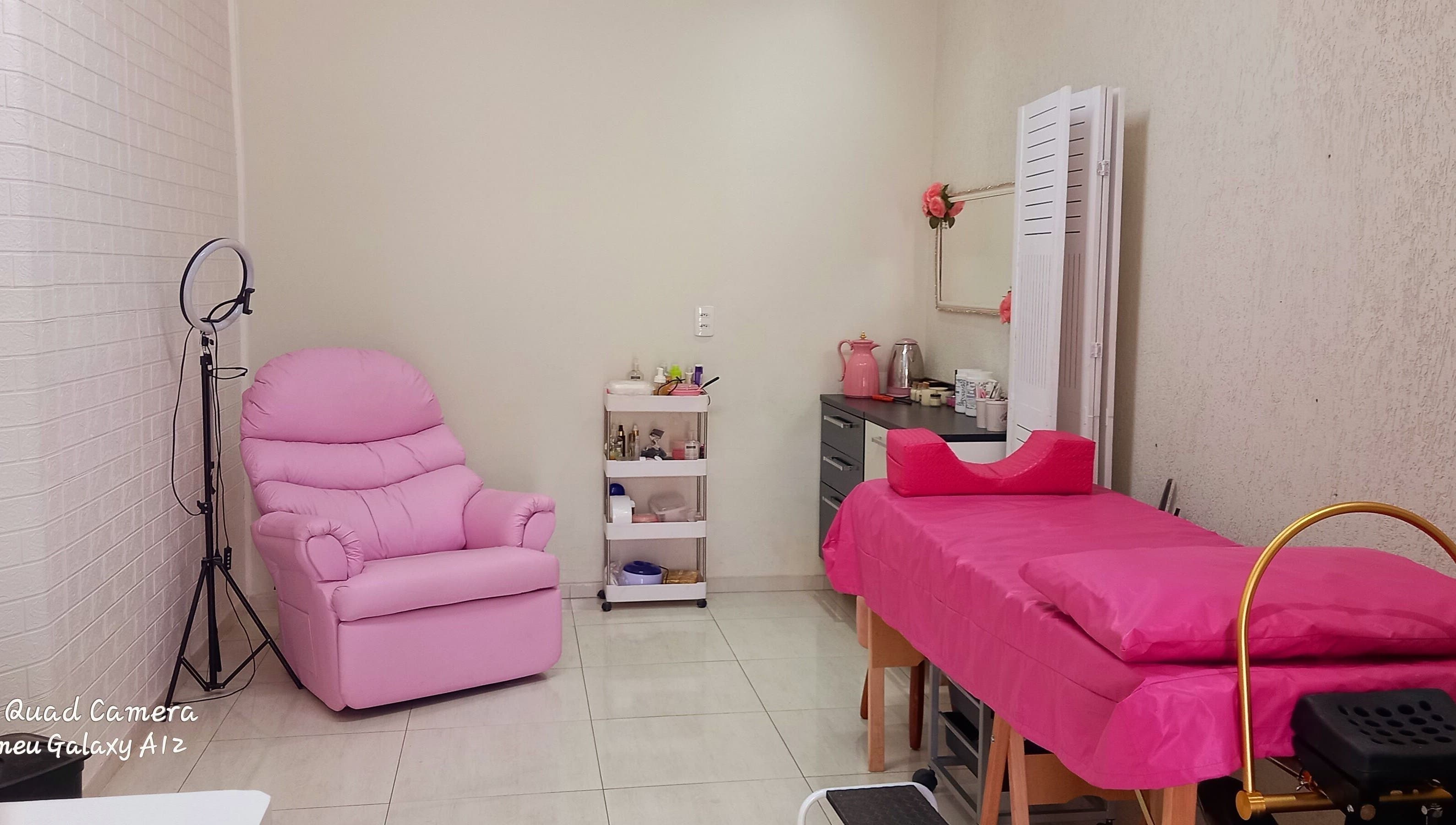 Sala de tratamento rosa no Espaço de Beleza em São Paulo, São Paulo, BR, com cadeira e maca confortáveis.