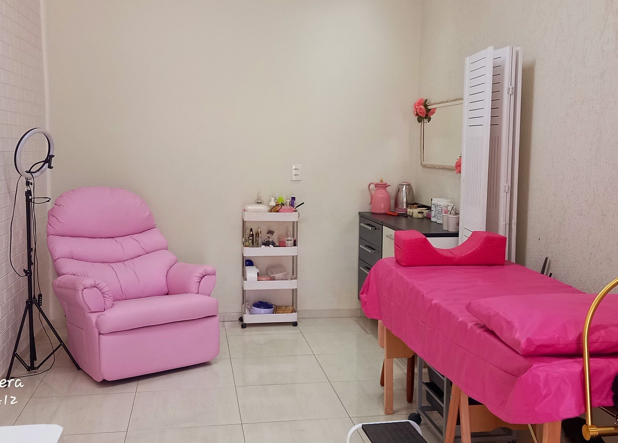 Sala de tratamento rosa no Espaço de Beleza em São Paulo, São Paulo, BR, com cadeira e maca confortáveis.