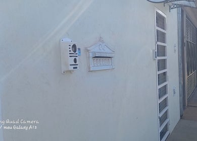 Parede branca na entrada do Espaço de Beleza em São Paulo, São Paulo, BR com caixa de correio decorativa.