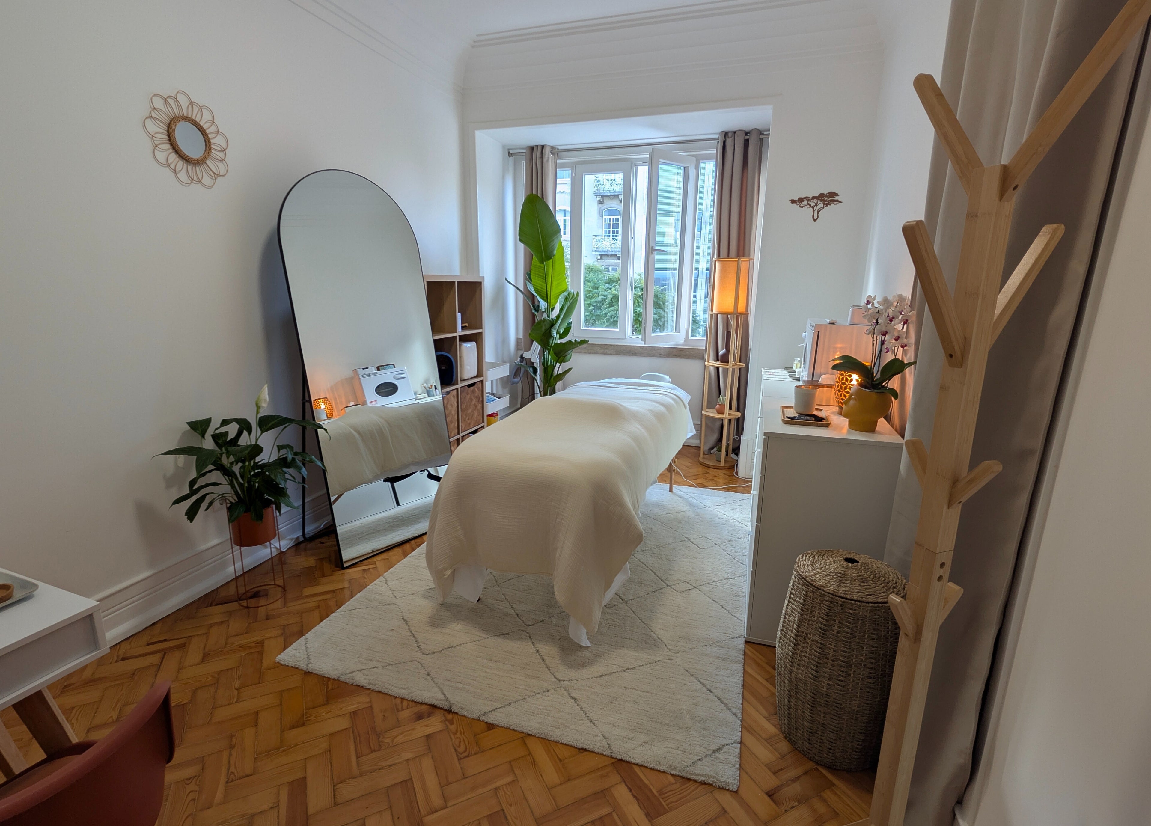 Sala de massagem tranquila no Daniela Dos Santos em Lisboa, PT, com decoração minimalista e plantas verdes.