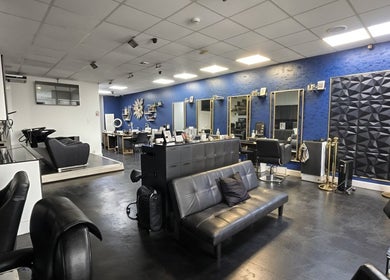 Elegant interior of Inhibition Hair & Beauty Salon, Telford, England, GB, featuring sleek black seating and mirrors.