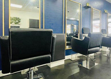 Elegant styling chairs in Inhibition Hair & Beauty Salon, Telford, England, GB with modern blue decor.