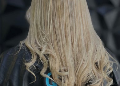Blonde hair styled at Inhibition Hair & Beauty Salon, Telford, England, GB, showcasing sleek, elegant curls.