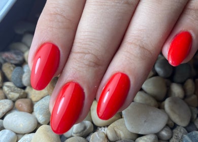 Red manicured nails on pebbles at Glamicious nails by Katia, L-imġarr, MT.