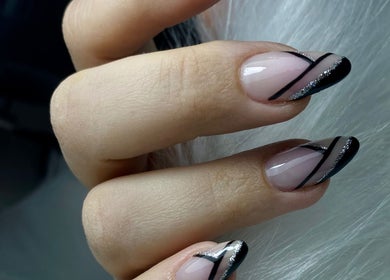 Chic nail design at Glamicious nails by Katia, L-imgarr, MT, featuring sleek black stripes and glitter.