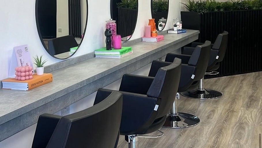 Chic salon interior at India Frances Makeup, Colwyn Bay, Wales, GB featuring modern styling chairs and large mirrors.
