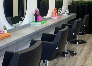 Chic salon interior at India Frances Makeup, Colwyn Bay, Wales, GB featuring modern styling chairs and large mirrors.