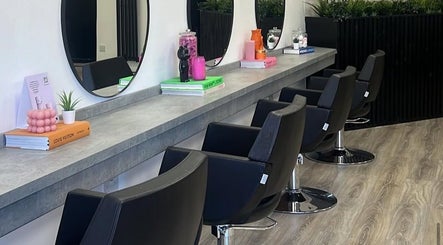 Chic salon interior at India Frances Makeup, Colwyn Bay, Wales, GB featuring modern styling chairs and large mirrors.