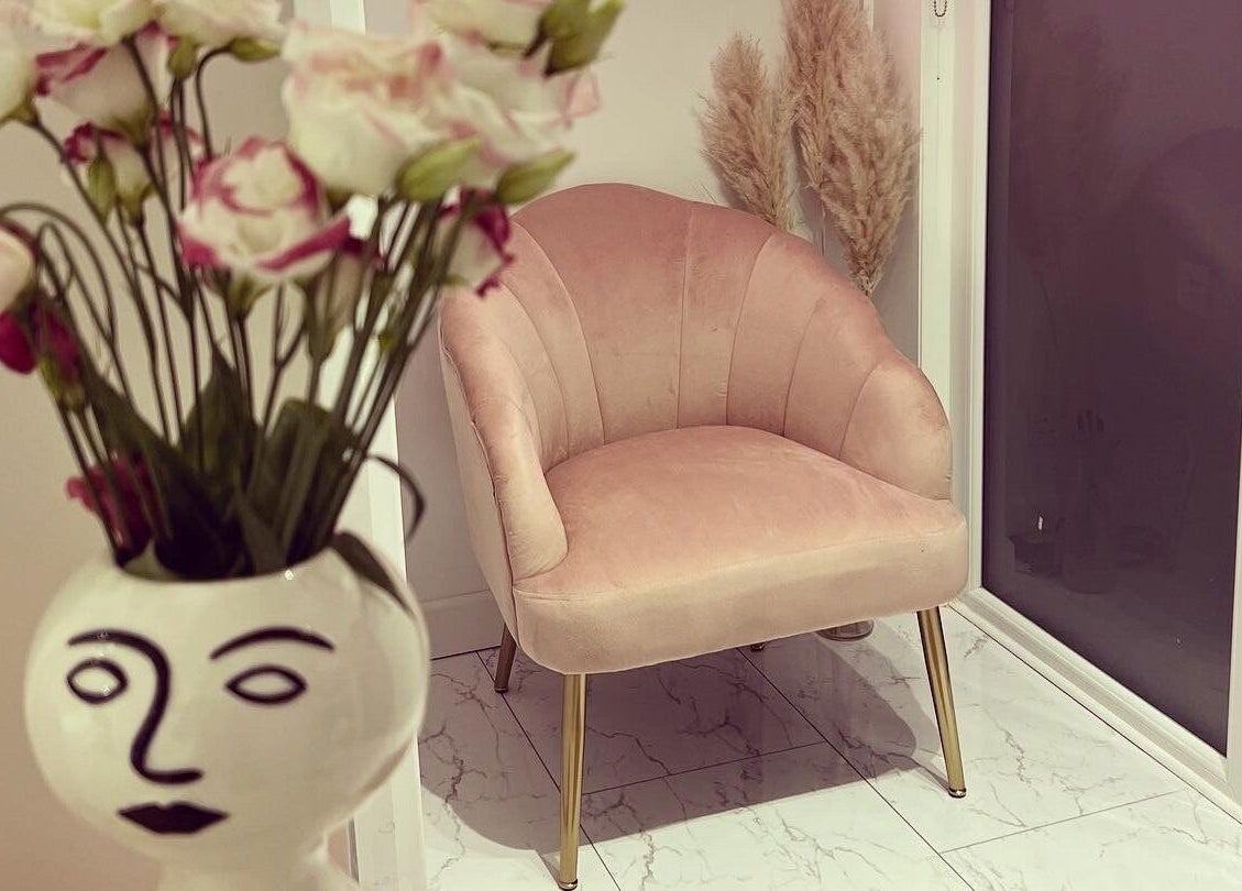 Elegant blush chair beside floral vase at Beauty by Felicity, Addlestone, England, GB.