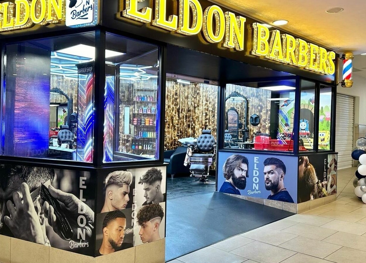 Eldon Barbers facade in Newcastle upon Tyne, England, GB, showcasing modern interior and vibrant signage.