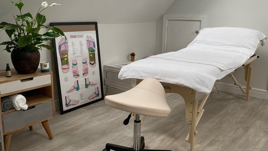 Cozy therapy room at Carole Coram Reflexology, Buckden, England, GB, with massage table and plant decor.