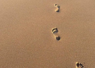 Footprints in sand symbolizing relaxation at Carole Coram Reflexology, Buckden, England, GB.