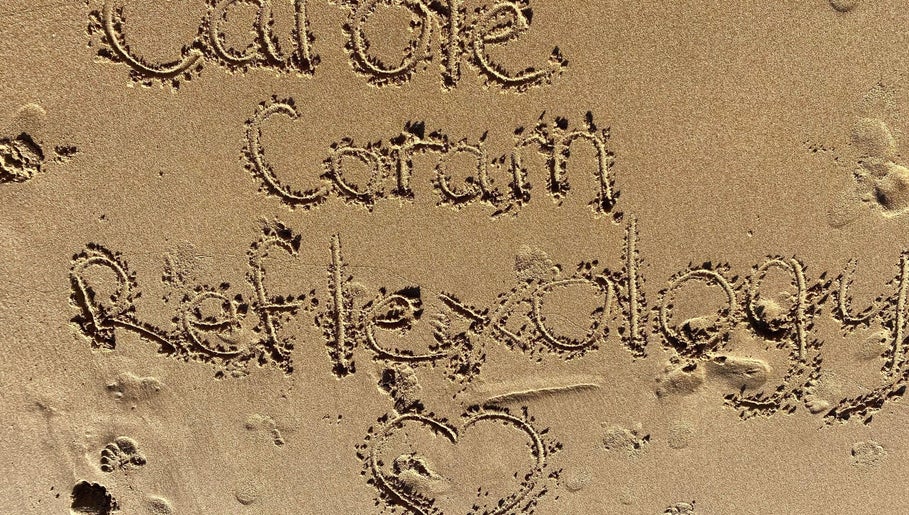 Carole Coram Reflexology written in sand at Buckden, England, GB beach, highlighting wellness and tranquility.