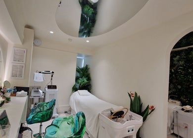 Relaxing treatment room at Hairmonic Head Spa, London, England, GB with plants, mirrors, and modern equipment.