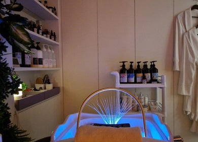 Relaxing spa interior at Hairmonic Head Spa London, England, GB showcasing premium beauty products and plush robes.