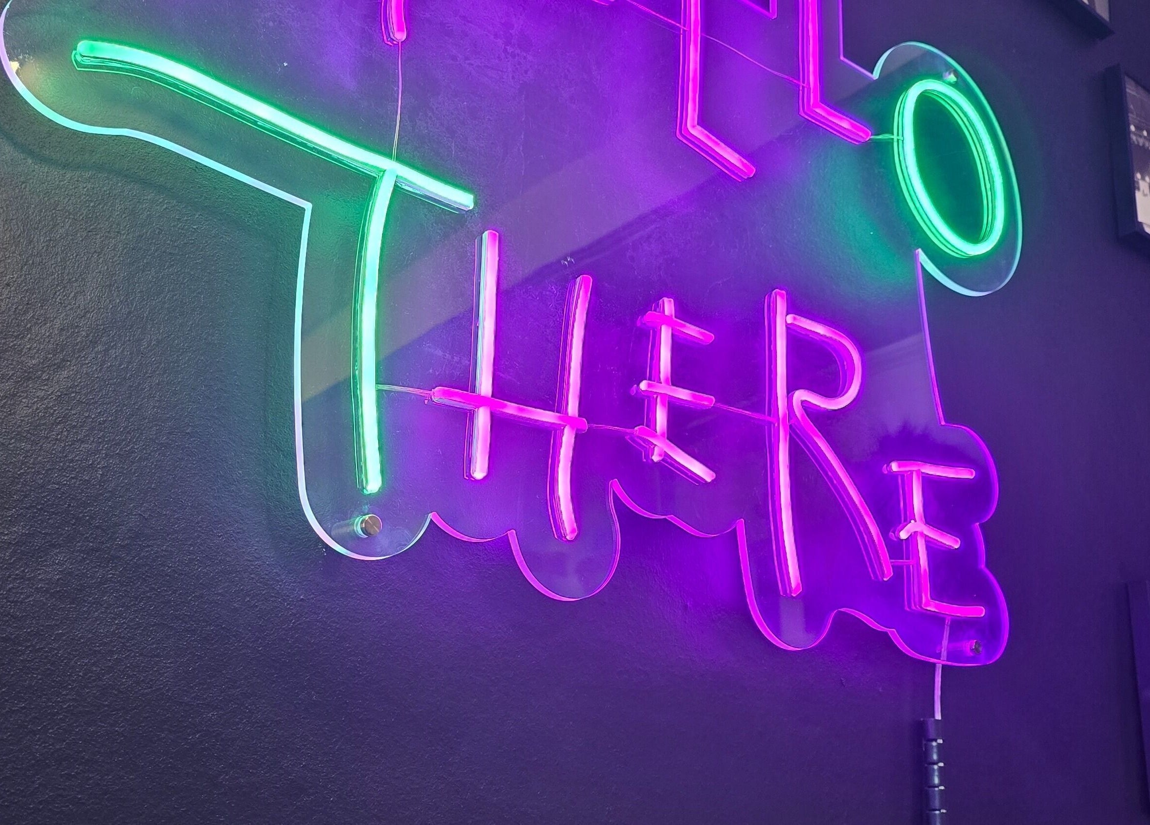 Vibrant neon sign at Rebel Manes, Drogheda, County Louth, IE, creating a lively salon atmosphere.