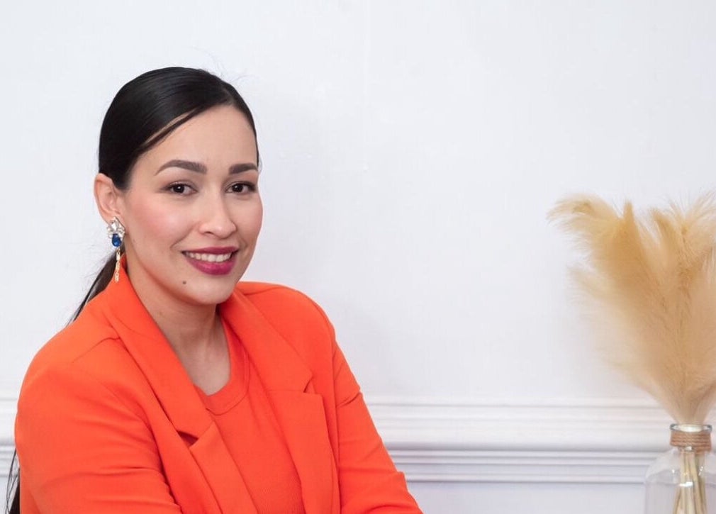 Mujer sonriente en blazer naranja en Gaby Quijada, Online, Georgia, US.