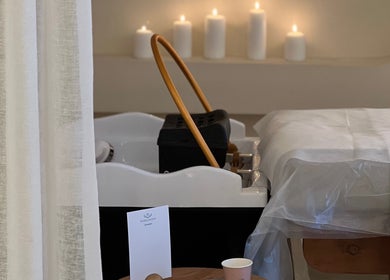 غرفة تدليك هادئة في سبا سباكنج، بريدة، منطقة القصيم، SA مع شموع مضاءة ومقاعد مريحة.